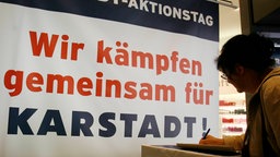 Plakat an einer Eingangstür zu einem Karstadt-Haus