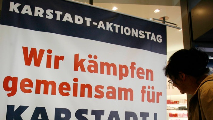 Plakat an einer Eingangstür zu einem Karstadt-Haus