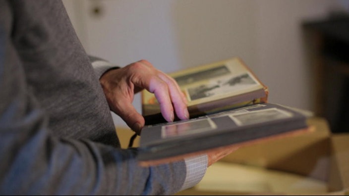 Rolf Bergmeier hält Fotoalbum in der Hand