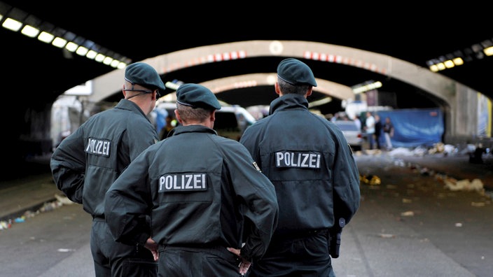 Polizisten stehen am 24.07.2010 in Duisburg auf der Loveparade an dem gesperrten Tunnel