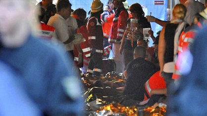 Rettungskräfte stehen im Tunnel vor abgedeckten Leichen