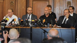 Duisburgs OB Adolf Sauerland, Loveparade-Veranstalter Rainer Schaller, stellv. Polizeipräsident von Duisburg Detlef von Schmeling sowie Ordnungsdezernent und Leiter des Krisenstabs Wolfgang Rabe (r-l) am Sonntag (25.07.10) bei einer Pressekonferenz auf dem Podium.