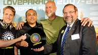 Moderator Oliver Pocher, Musikproduzent Anthony Rother, der Loveparade-Geschaeftsfuehrer Rainer Schaller und der Oberbuergermeister der Stadt Duisburg, Adolf Sauerland, posieren bei  einer Pressekonferenz zur Loveparade 2010 mit einer Vinylscheibe.