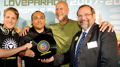 Moderator Oliver Pocher, Musikproduzent Anthony Rother, der Loveparade-Geschaeftsfuehrer Rainer Schaller und der Oberbuergermeister der Stadt Duisburg, Adolf Sauerland, posieren bei  einer Pressekonferenz zur Loveparade 2010 mit einer Vinylscheibe.