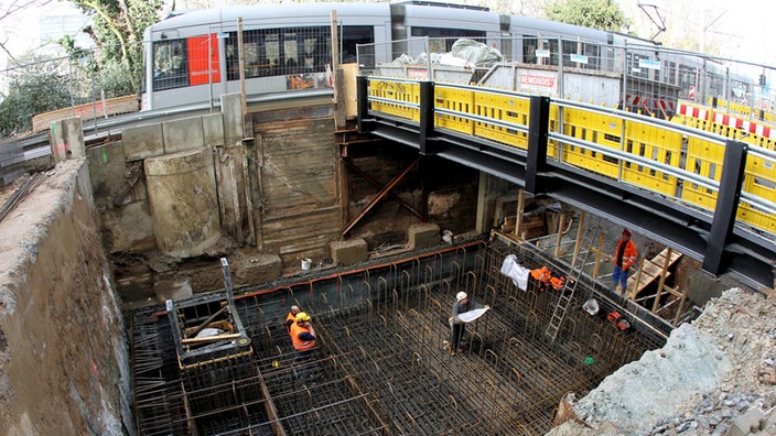 Straßenbahn fährt an U-Bahnbaustelle in Düsseldorf vorbei