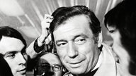 Yves Montand mit Fotografen