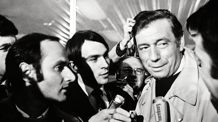 Yves Montand mit Fotografen