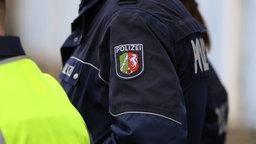 Seitliche Aufnahme der Schulterpartie einer uniformierten, polizeizugehörigen Person.