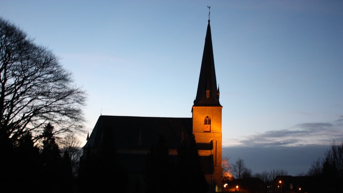 Angeleuchtete Kirche in der Dämmerung