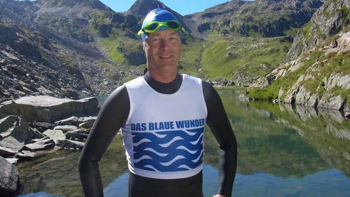 Sportler in Schwimmbekleidung vor einem See