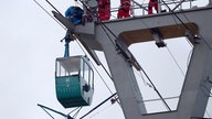 Höhenretter der Berufsfeuerwehr sichern eine Gondel der Rheinseilbahn in Köln ab