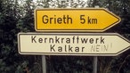 Wegweiser nach Grieth und beschmiertes Hinweisschild zum Kernkraftwerk Kalkar