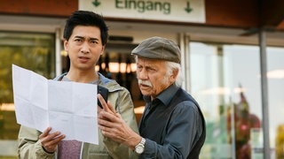 Edwin (Tilo Prückner, r.) und Hui (Aaron Le, l.) orientieren sich mit dem Lageplan des Zoos.