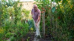 Peter Hamburger mit einer Gartenharke. 