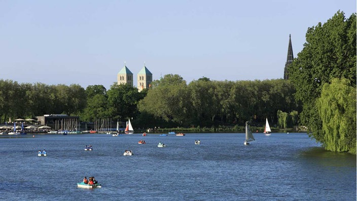 Segelboote auf dem Aasee in Münster, im Hintergrund Bäume und Kirchtürme