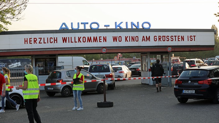 Vor der Einfahrt zum Autokino Porz regeln Ordnunghüter den Verkehrsandrang.