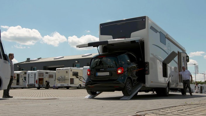 Ein Kleinwagen wird in ein Reisemobil verladen