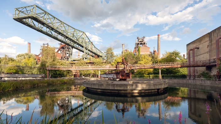 Rundklärbecken mit Wasserspiegelung von Industriebauten