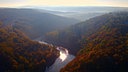 Blick auf einen Fluss im bewaldeten Eifeltal