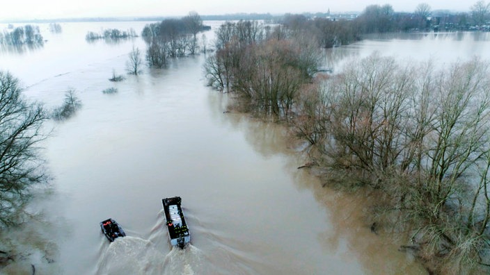 Luftaufnahme auf den überschwemmten Niederrhein, auf dem ein Transport- und ein Schlauchboot fahren