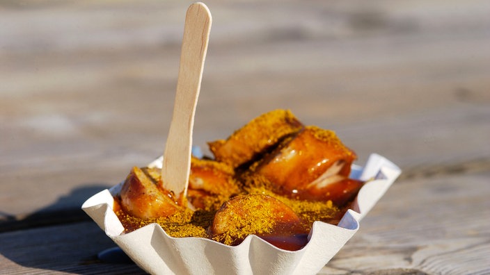 Eine Currywurst mit Holzgabel