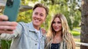 Daniel Sommer und Marie Reim stehen im Park und machen ein Selfie von sich