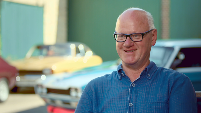 Walter Winkler beim Interview, im Hintergrund mehrere Ford Capri