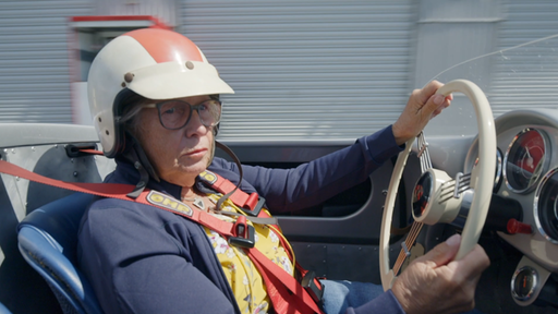 Hannelore Werner sitzt in einem alten Rennwagen