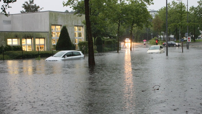 Zwei Autos stehen am 28.07.2014 auf einer überfluteten Straße in Münster. 