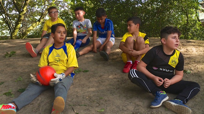 Sechs Jungen in Fußballtrikots