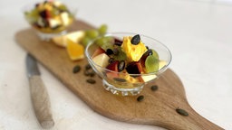 Obstsalat in Schüssel auf einem Holzbrett