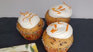 Orangenmuffins mit Frosting und Orangenschalenverzierung