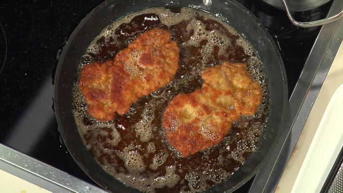 Zwei Schnitzel braten in der Pfanne.