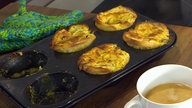 Form mit mehreren Soufflés, daneben eine Tasse Kaffee