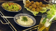 Grüne Falafel mit Beilagen in Schüsseln