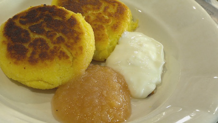 Kartoffelplinsen mit Apfemus und Quark auf einem Teller angerichtet