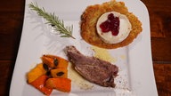 Zickleinkeule an Kartoffelpuffer mit Ziegenbrie und Wildpreiselbeeren