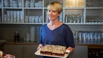 Anne Lee-Bolhöfer in der Küche mit einem Kuchen. 