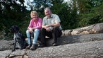 Barbara Hillejan mit ihrem Mann auf einem Holzstamm.