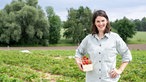  Inga Flachmeier auf dem Feld mit einere Schale Erdbeeren.