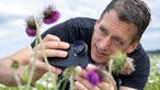 Jochen Kanders fotografiert auf seiner Blumenwiese. 