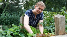 Katharina erntet Gemüse aus dem Hochbeet