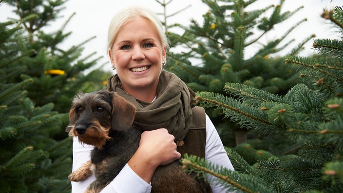 Katharina Püning mit dackel zwischen Tannen. 