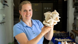 Katharina Marseille mit einem Austernpilz in der Hand. 