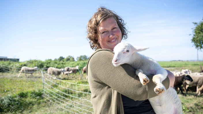 Anja Wolff mit einem Lamm auf dem Arm.