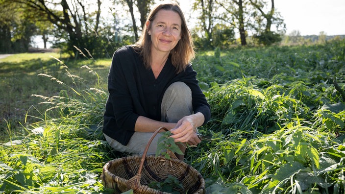 Christine Huber mit einem Korb Kräuter.