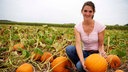 Lea Unterhansberg auf dem Feld mit einem Kürbis. 