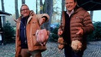 Frank Buchholz und Björn Freitag tragen eine Pute und Gemüse zum Grill. 