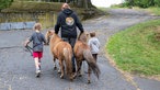 Marie Owens mit zwei Kindern und Ponys. 