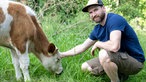 Melvin Berger mit einer Kuh auf der Weide.